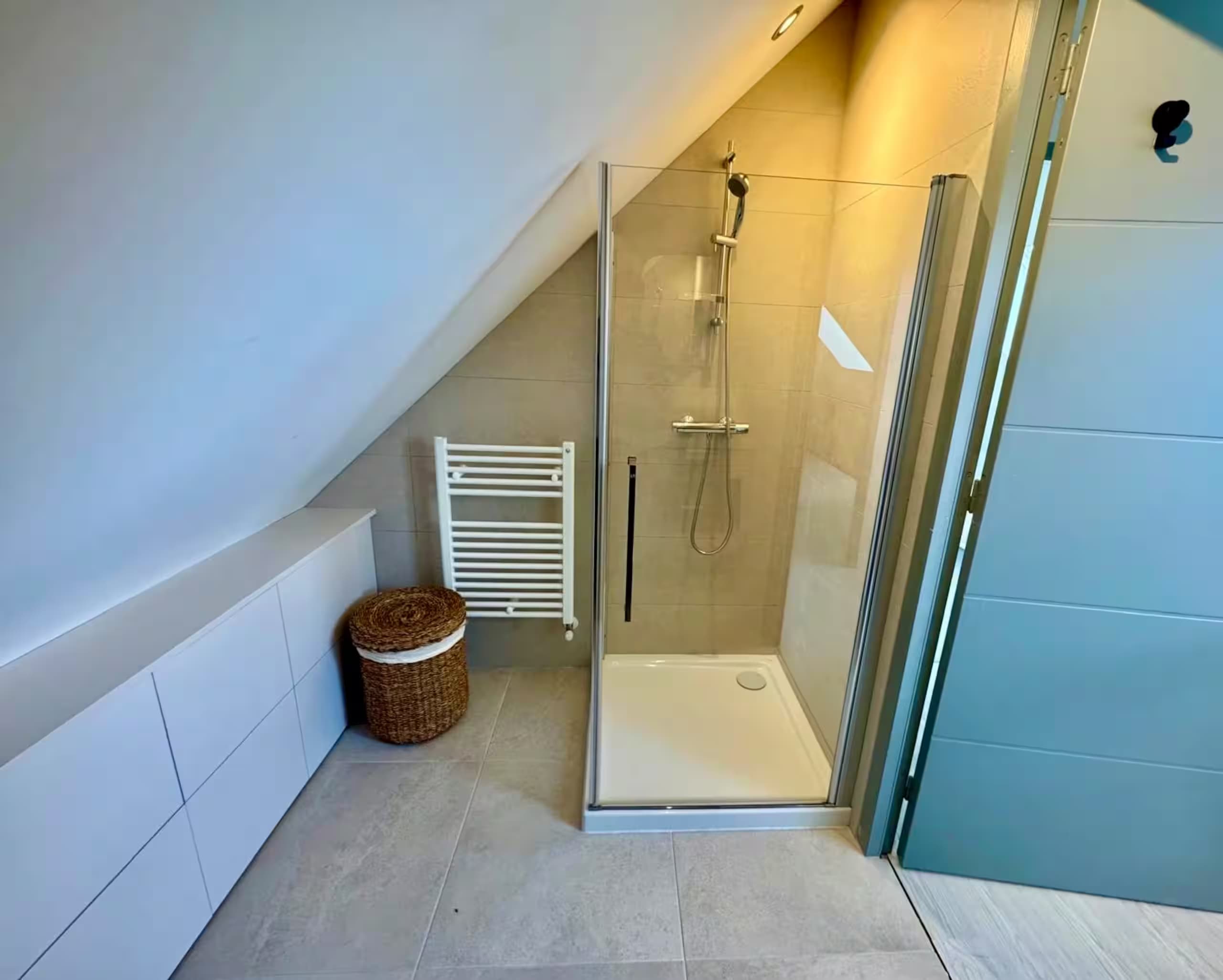 Salle d’eau mansardée avec douche et sèche-serviettes