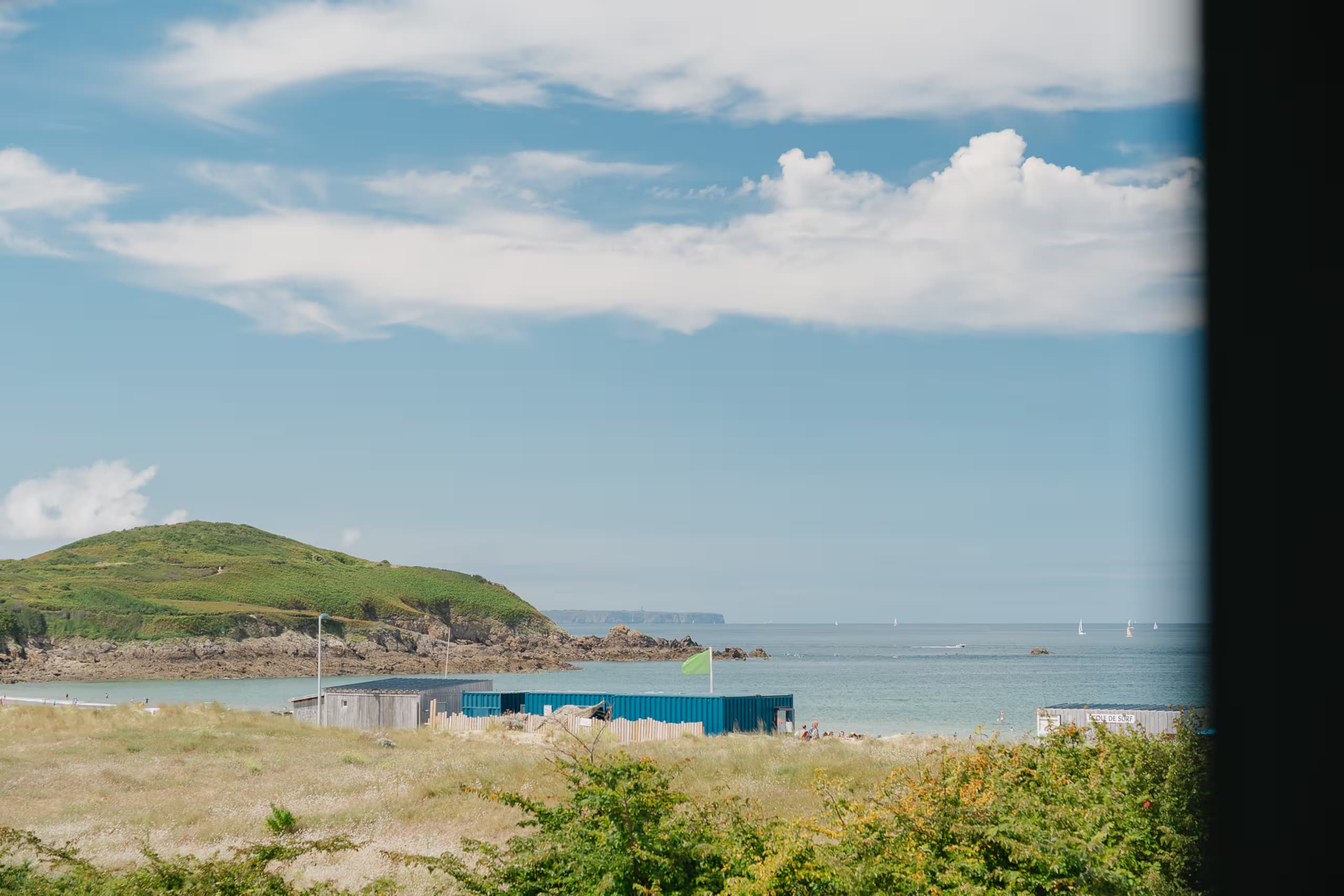 Vue sur la plage, la pointe verdoyante et la mer d’Émeraude
