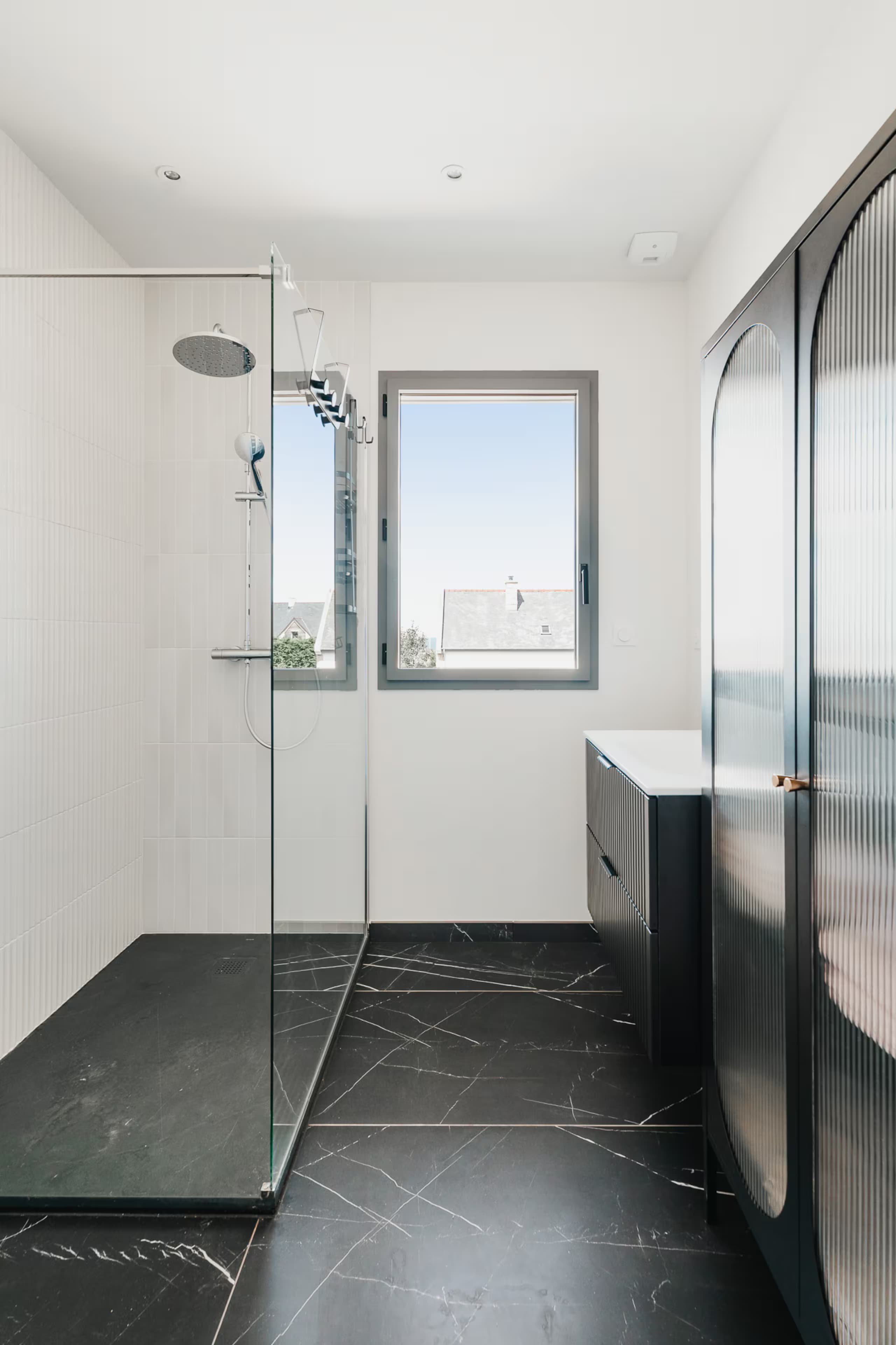 Salle d’eau avec douche à l’italienne et sol en marbre noir