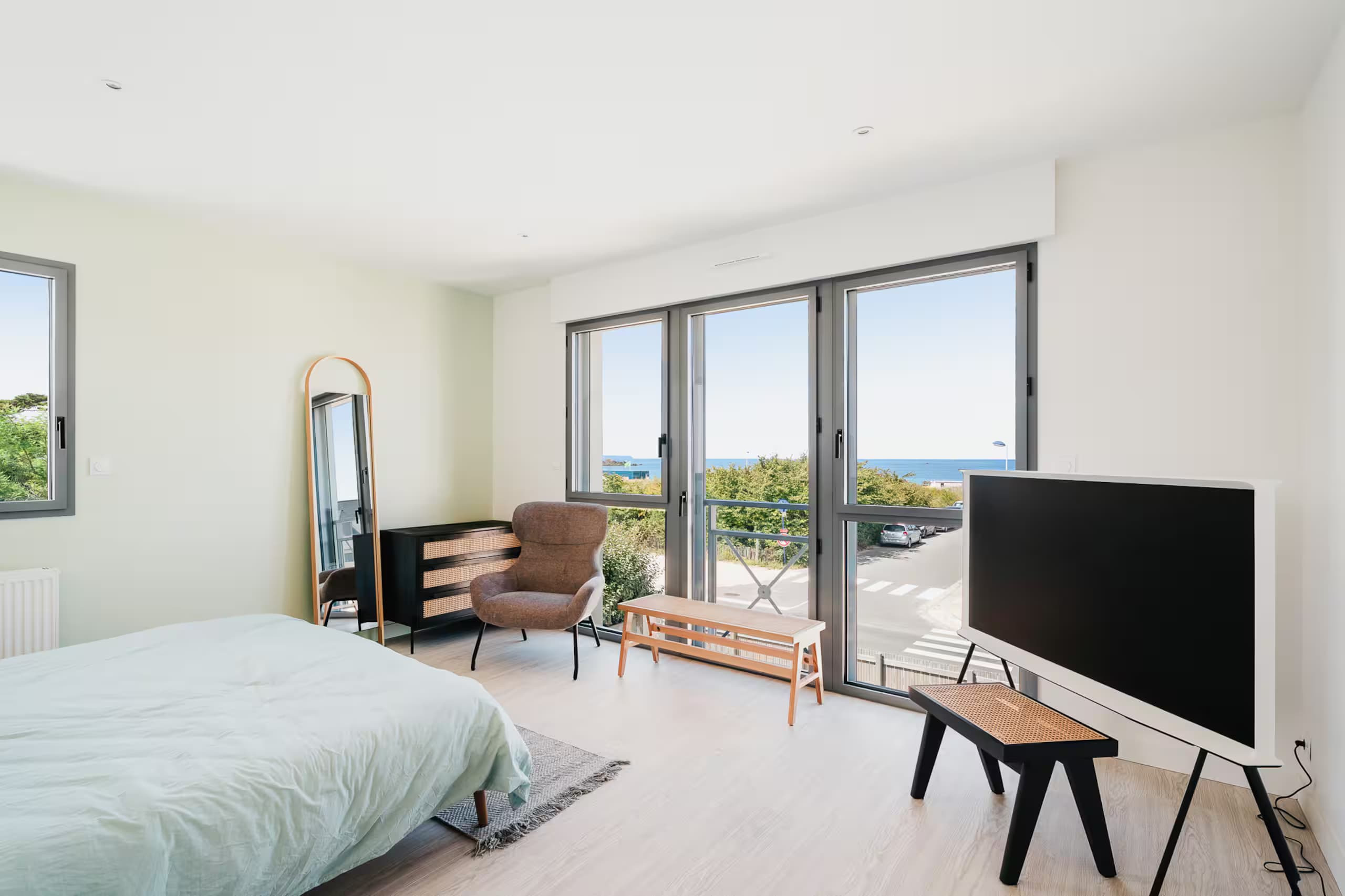 Chambre avec grandes baies vitrées ouvrant sur la mer