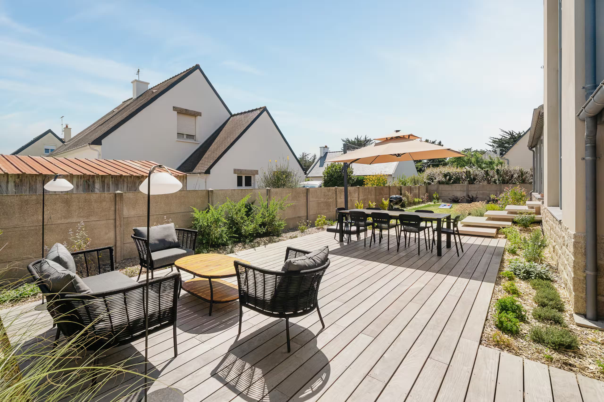 Terrasse avec fauteuils, table basse et jardin paysager