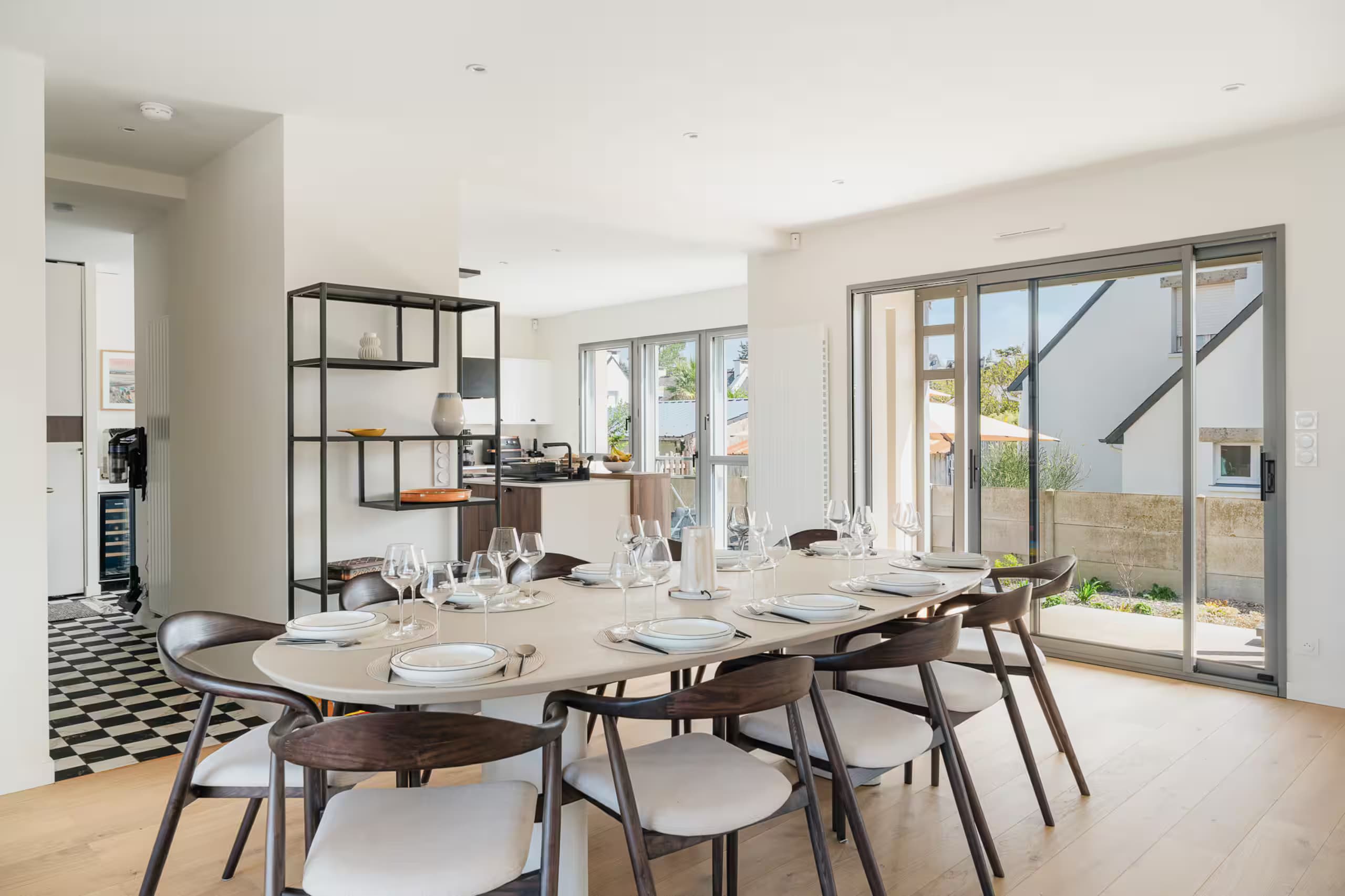 Longue table dressée, ouverte sur la cuisine