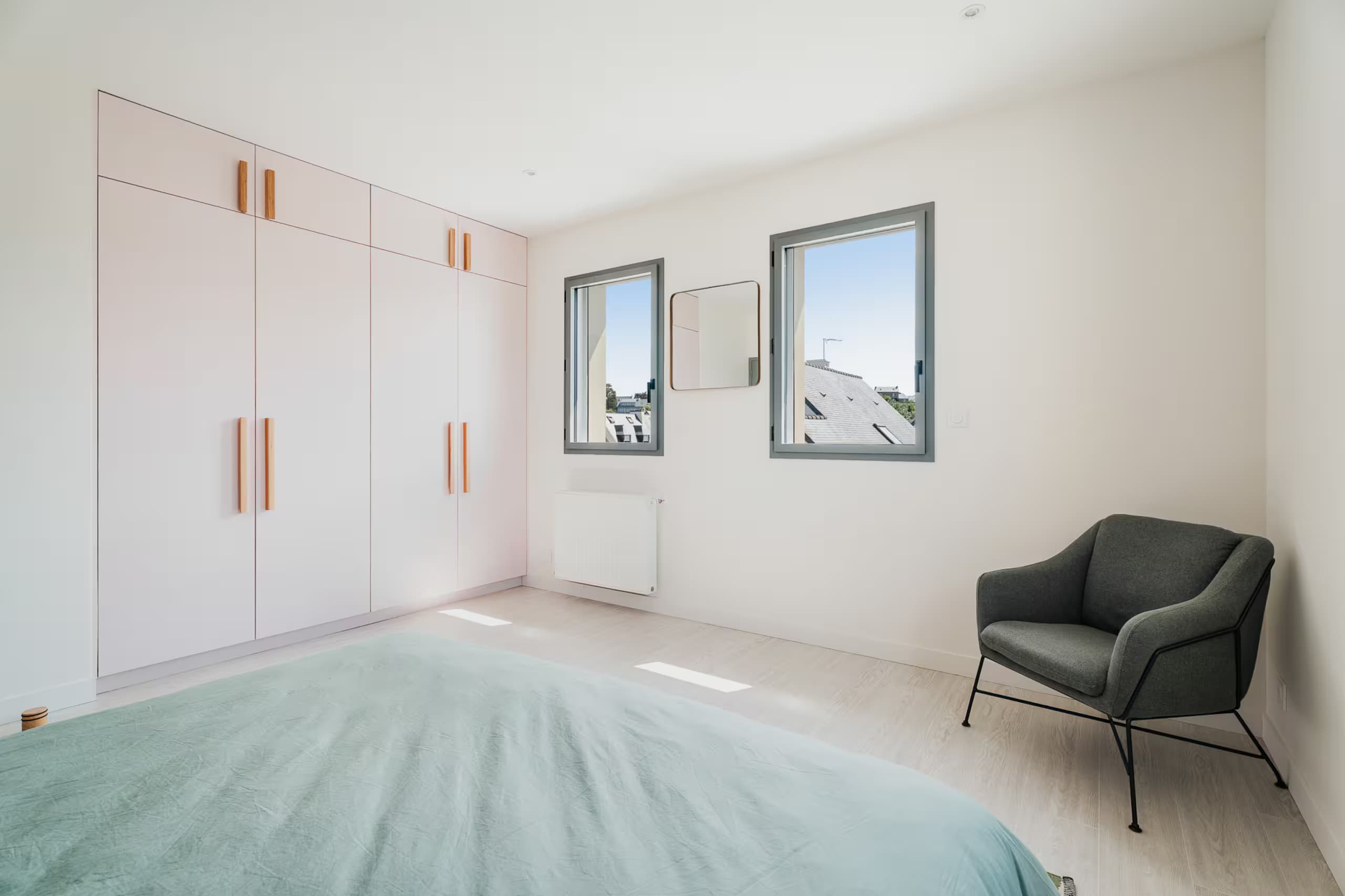Chambre claire avec placards et fauteuil