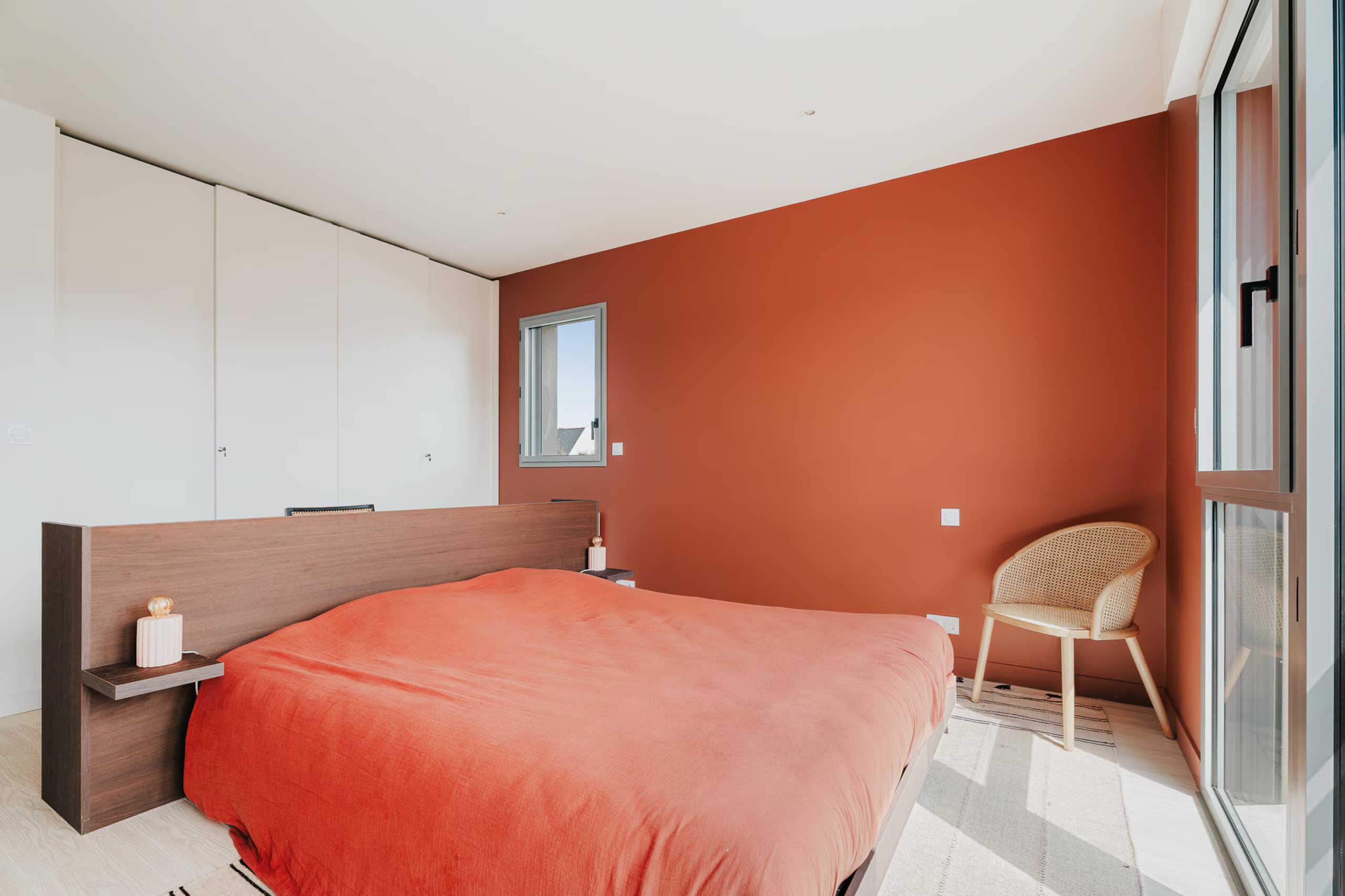 Chambre avec mur terracotta et lit double