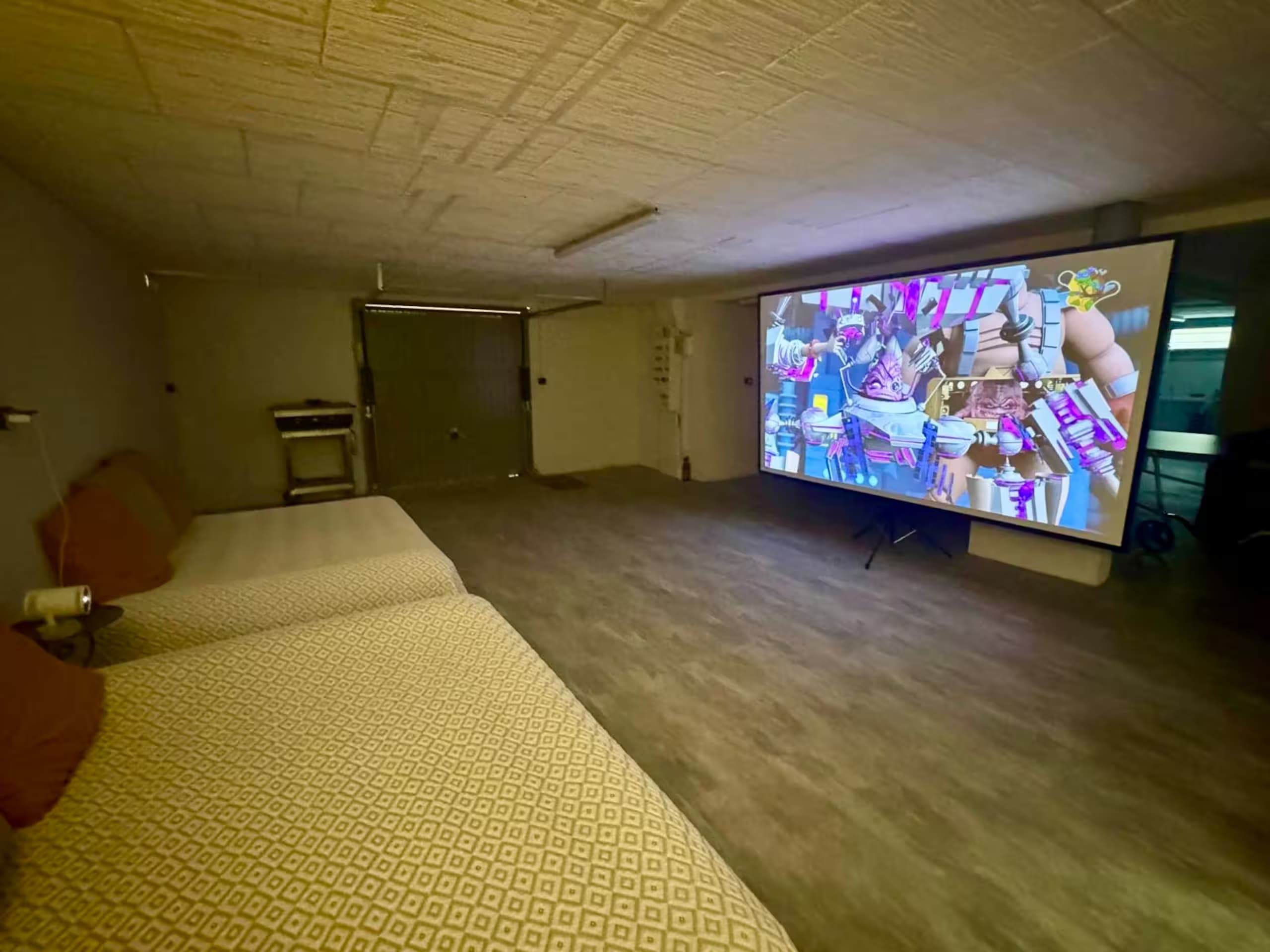 Grand écran de projection allumé face à des couchages