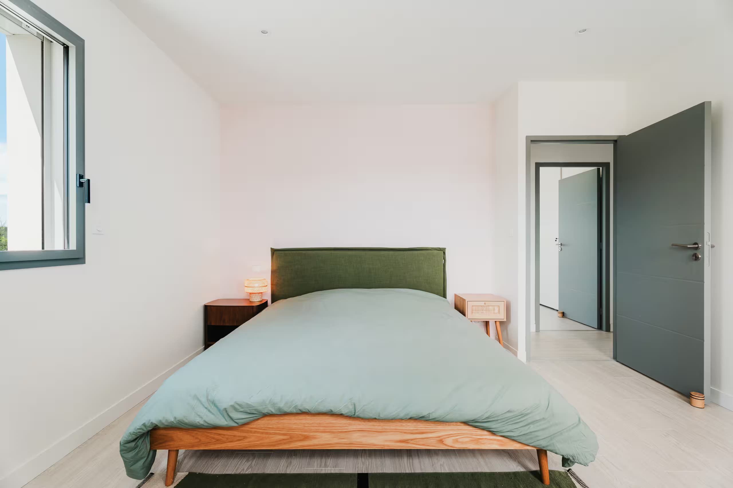 Chambre avec lit double et tête de lit verte