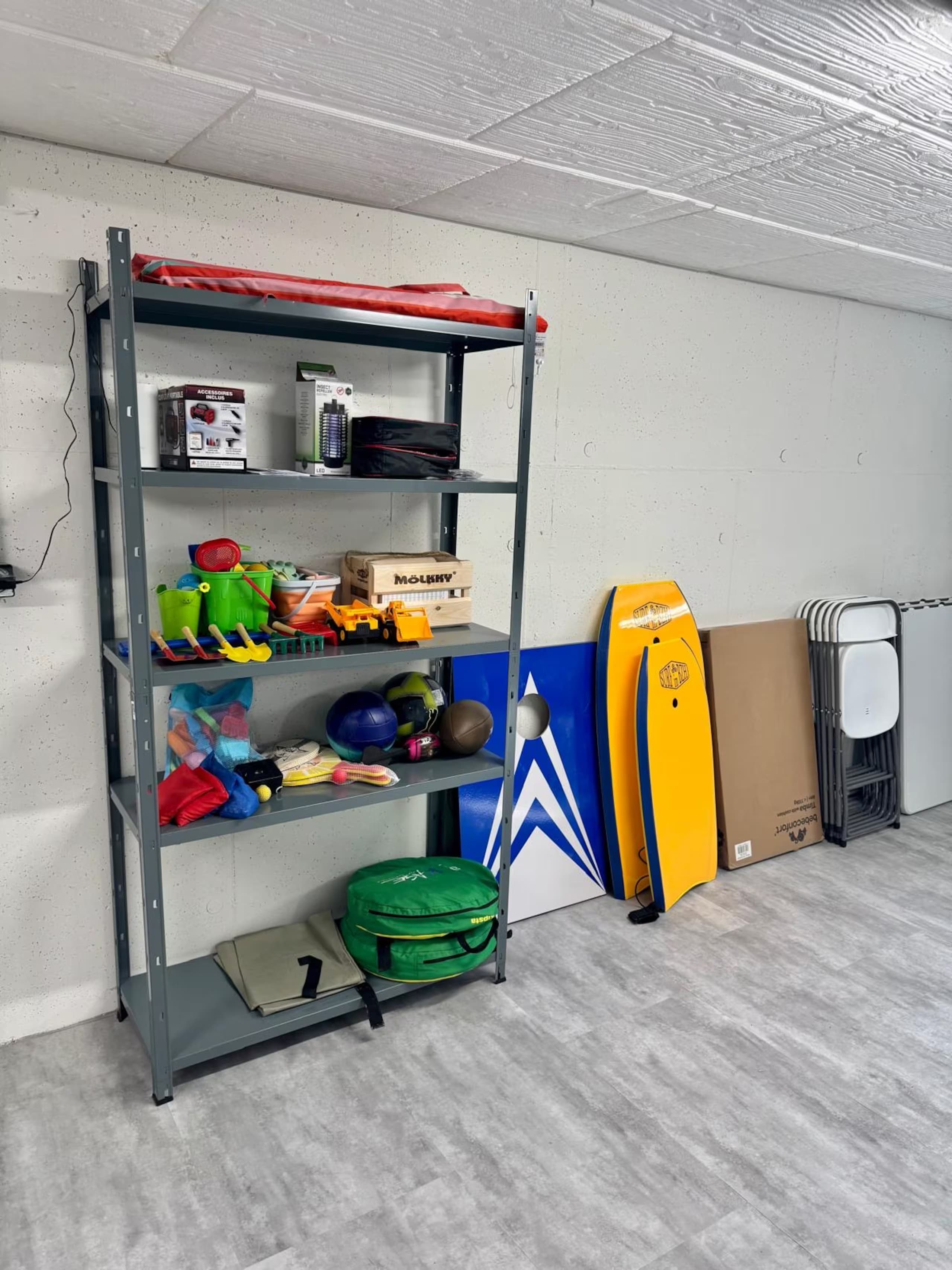 Étagère avec jeux de plage, bodyboards et matériel