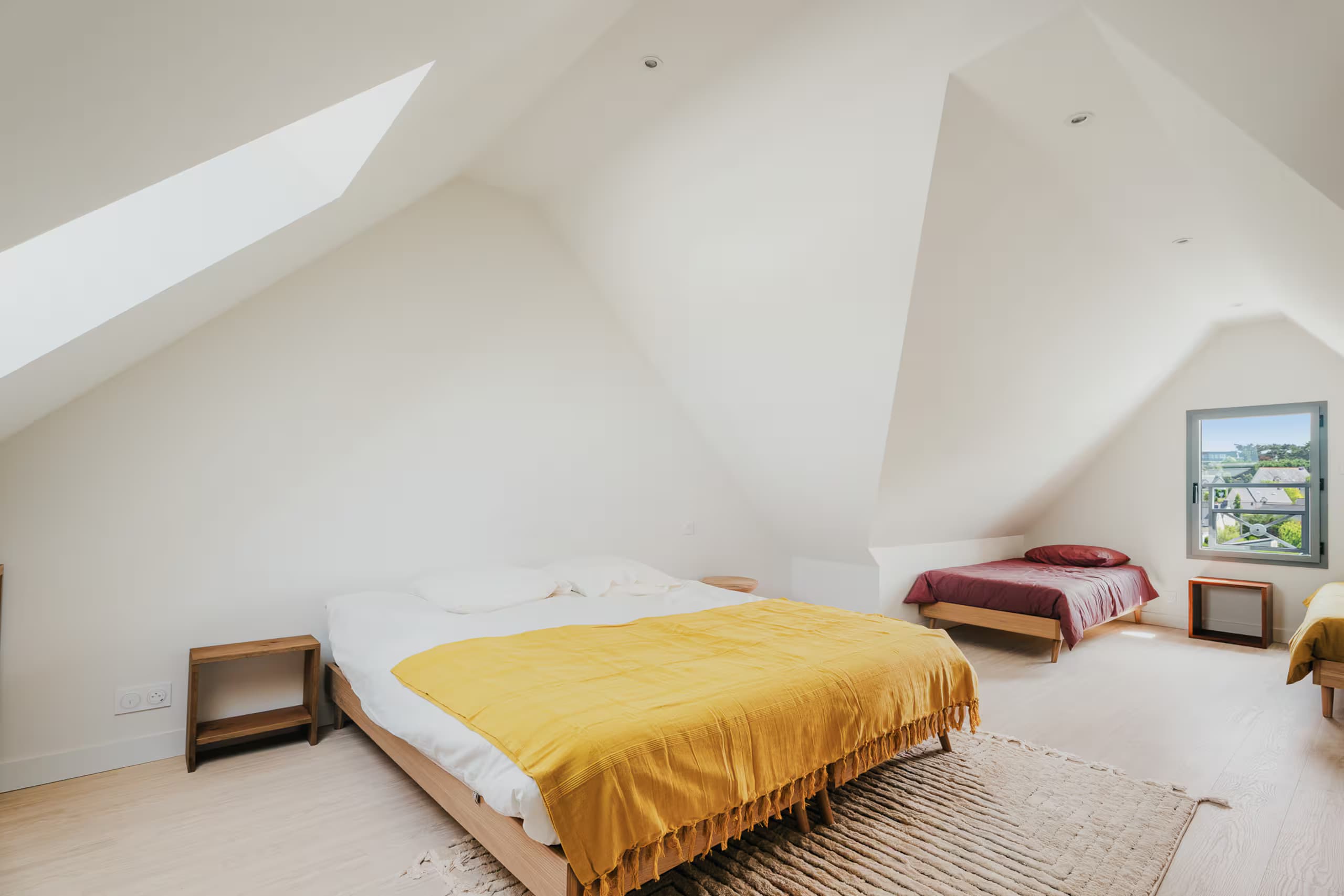 Pièce mansardée avec un lit double et des couchages d’appoint
